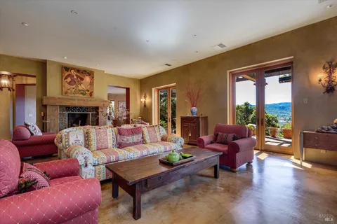 a living room with furniture fireplace and a large window