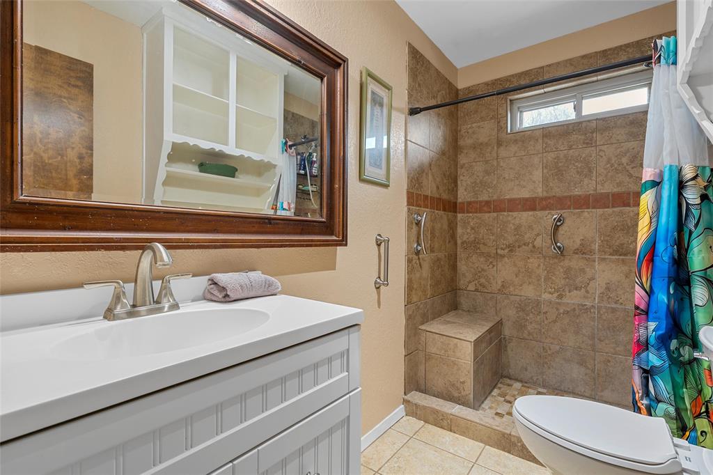 1038 South Old Robinson Road Robinson, TX 76706 - Photo 16 of 36 Bathroom featuring vanity, a stall shower, light tile patterned floors, and a textured wall