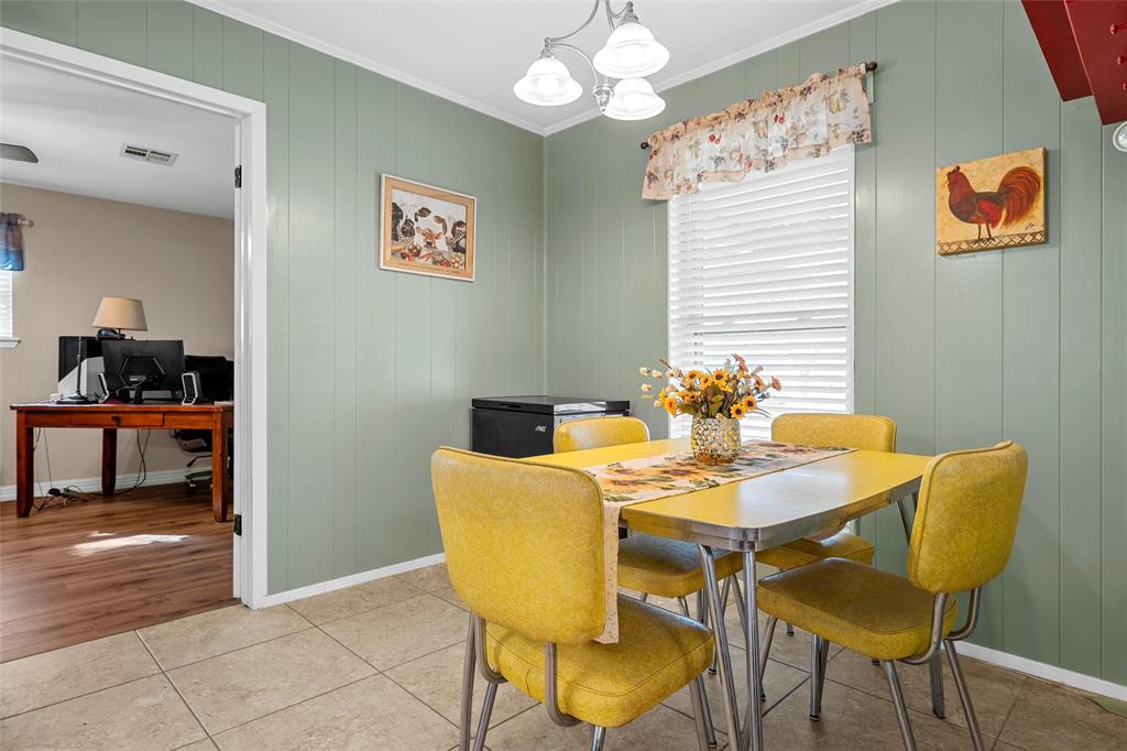 1038 South Old Robinson Road Robinson, TX 76706 - Photo 6 of 36 Dining room featuring ornamental molding, hanging lights, an office area, tile patterned floors, and wood walls