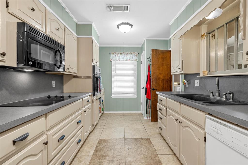 1038 South Old Robinson Road Robinson, TX 76706 - Photo 9 of 36 Kitchen featuring ornamental molding, cream cabinets, black appliances, backsplash, and light tile patterned floors