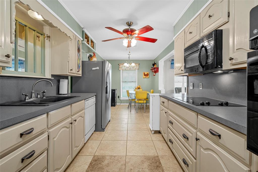 1038 South Old Robinson Road Robinson, TX 76706 - Photo 10 of 36 Kitchen featuring dark countertops, black appliances, cream cabinets, tasteful backsplash, and crown molding