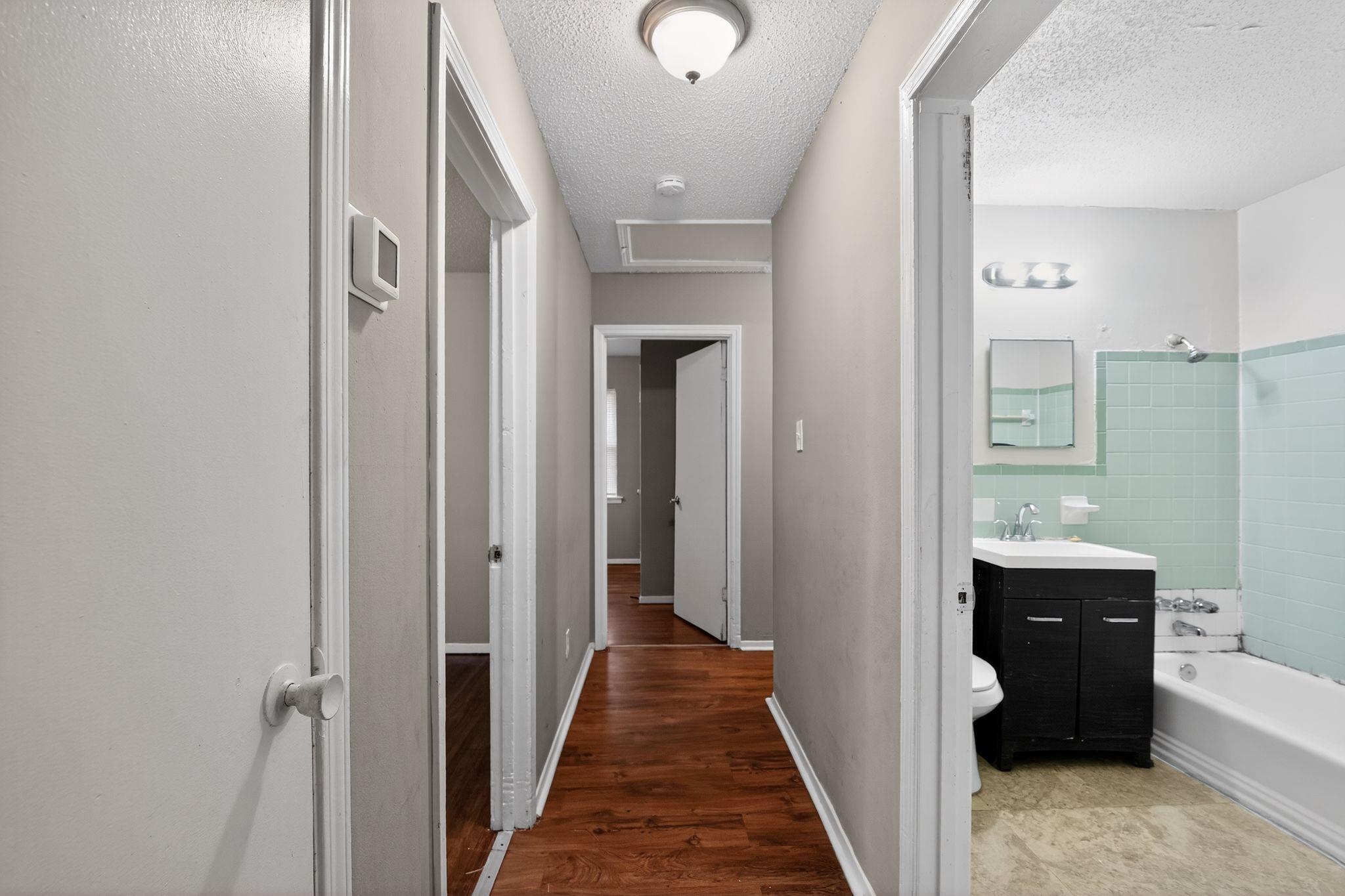 4314 Ford Road Memphis, TN 38109 - Photo 29 of 31 Hall with a textured ceiling, attic access, and wood finished floors