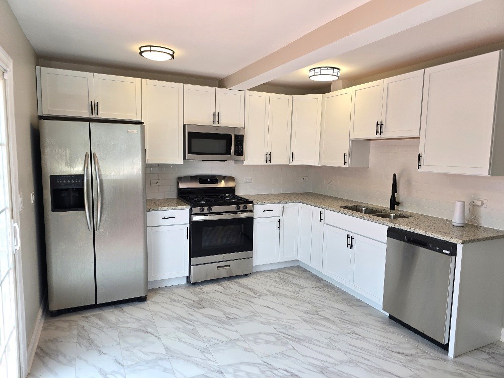 5657 North Parkside Avenue Chicago, IL 60646 - Photo 14 of 29 a kitchen with stainless steel appliances a refrigerator sink and microwave