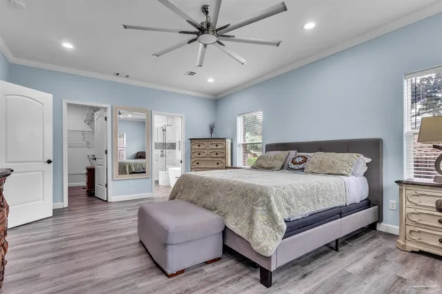 a spacious bedroom with a bed a couch and a chandelier