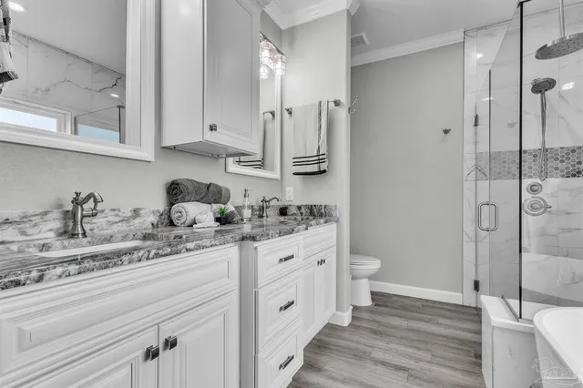 a bathroom with a granite countertop sink toilet and shower