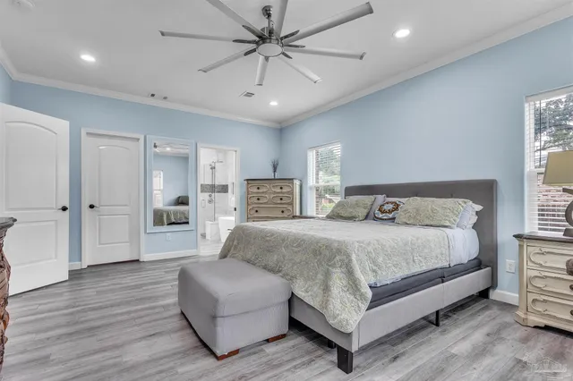 a spacious bedroom with a bed a couch and a ceiling fan