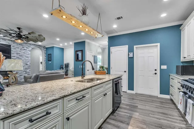 a kitchen with stainless steel appliances granite countertop a sink a counter space and cabinets
