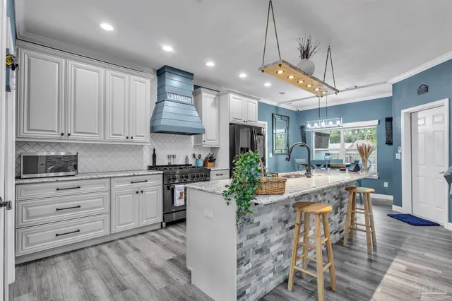 a kitchen with kitchen island granite countertop lots of wooden cabinets stainless steel appliances and dining table