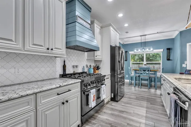 a kitchen with stainless steel appliances granite countertop a stove and a refrigerator
