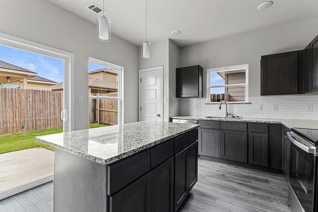 620 Alameda Road Azle, TX 76020 - Photo 6 of 27 a kitchen with granite countertop a sink and a stove top oven