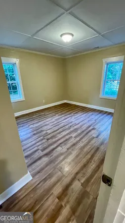 a view of an empty room with wooden floor