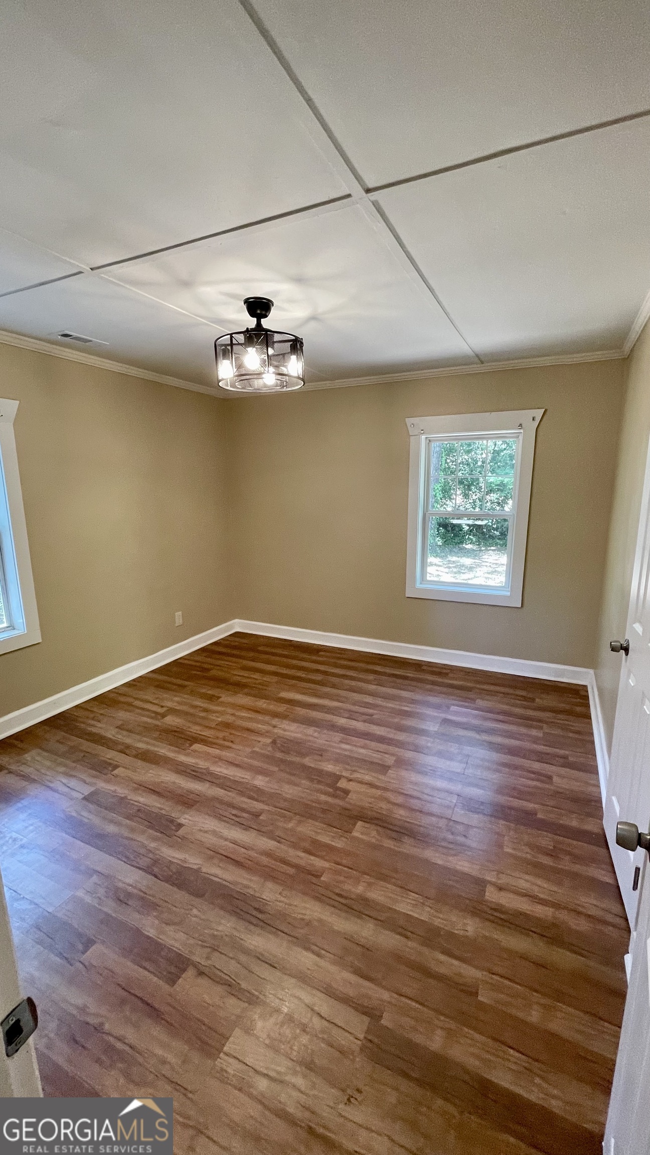 611 West Moore Street Dublin, GA 31021 - Photo 16 of 17 an empty room with wooden floor and windows