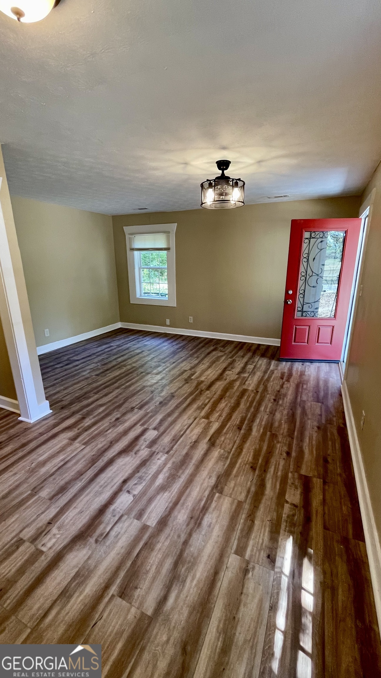 611 West Moore Street Dublin, GA 31021 - Photo 7 of 17 a view of an empty room with window and wooden floor