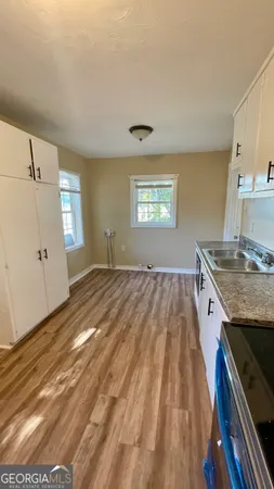 a view of a kitchen cabinets a sink and wooden floor