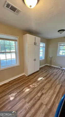 a view of empty room with window and wooden floor