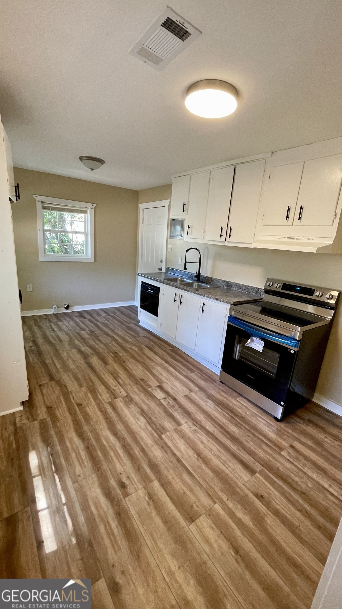 611 West Moore Street Dublin, GA 31021 - Photo 9 of 17 a kitchen with stainless steel appliances a stove a sink and a refrigerator
