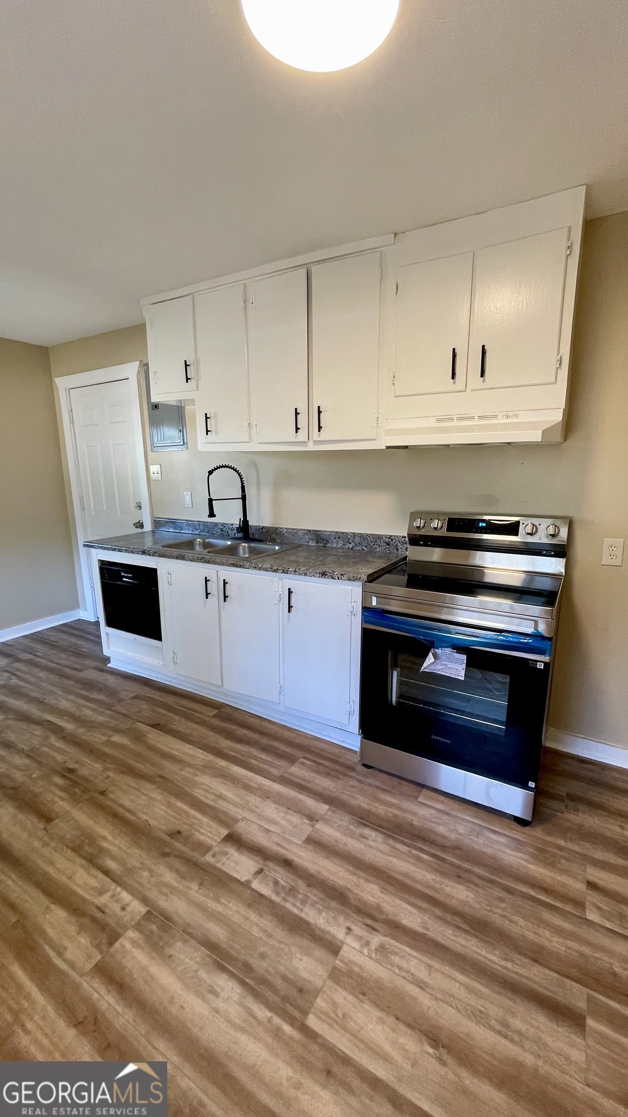 611 West Moore Street Dublin, GA 31021 - Photo 10 of 17 a kitchen with stainless steel appliances granite countertop a stove a sink and a microwave