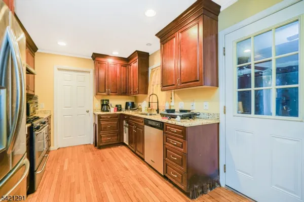 a kitchen with wooden floors and stainless steel appliances