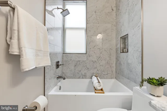 a view of staircase with lots of frames on wall and a wooden floor