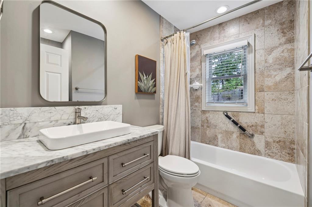 1952 Wingate Road Chamblee, GA 30341 - Photo 12 of 23 a bathroom with a granite countertop sink a toilet a mirror and shower