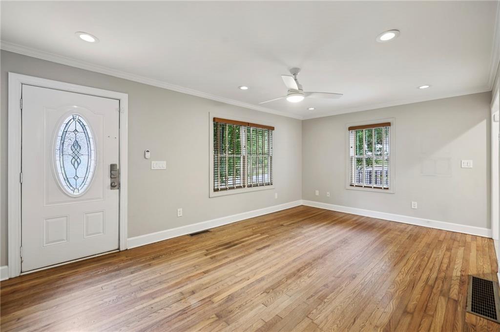 1952 Wingate Road Chamblee, GA 30341 - Photo 3 of 23 an empty room with wooden floor a ceiling fan and windows