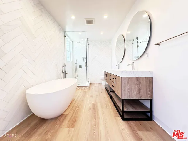 a living room with furniture a mirror and a wooden floor