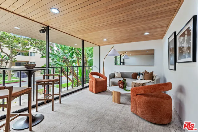 a living room with furniture and a floor to ceiling window