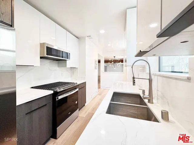 a kitchen with granite countertop a stove and a sink