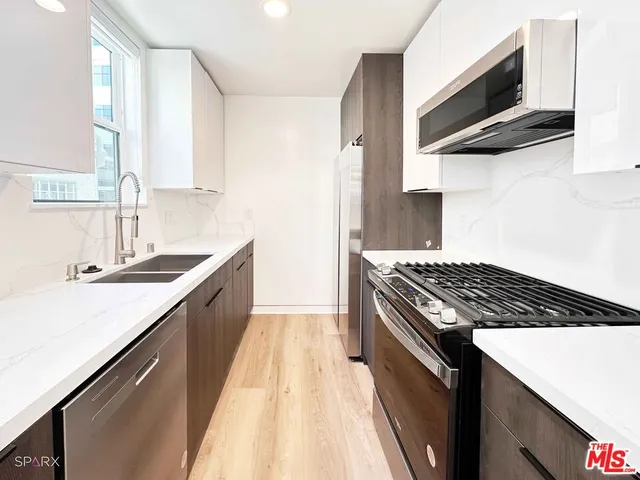 a kitchen with granite countertop a sink stove and cabinets