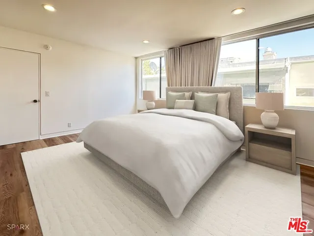 a bedroom with a bed and a large window