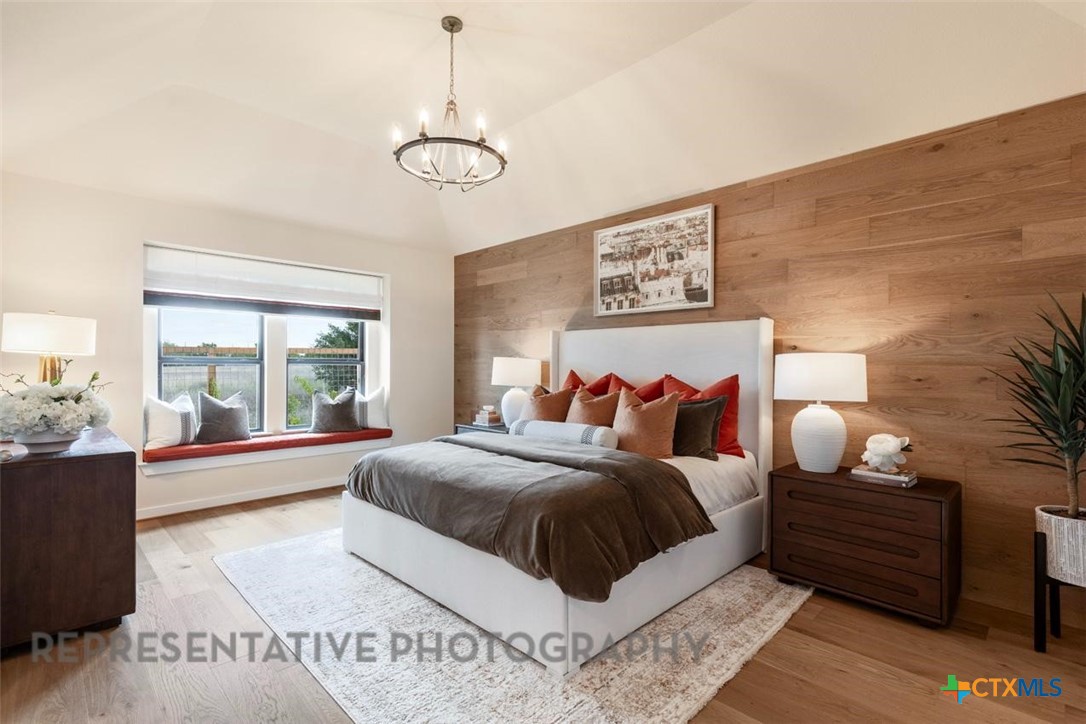 9501 Boathouse Drive Austin, TX 78744 - Photo 20 of 32 a bedroom with a large bed and a chandelier