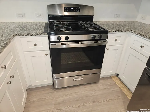 a white stove top oven sitting inside of a kitchen