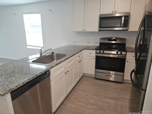 a kitchen with granite countertop a sink and a stove