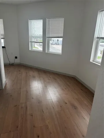 a view of wooden floor and windows in a room