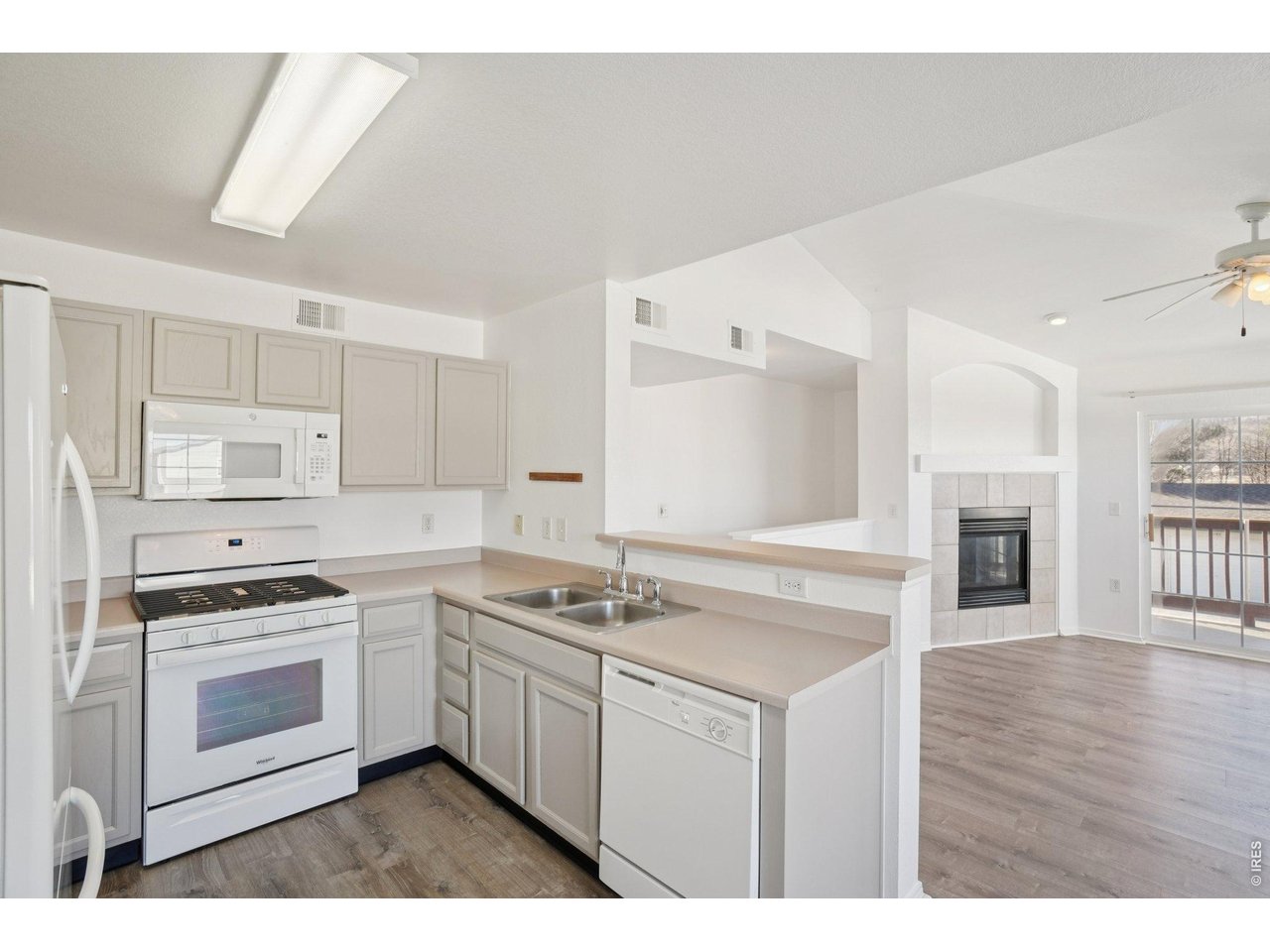 3002 West Elizabeth Street, Unit 16G Fort Collins, CO 80521 - Photo 13 of 29 a kitchen with white cabinets appliances and wooden floor