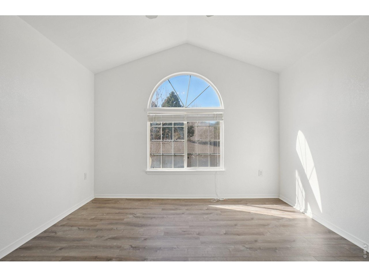 3002 West Elizabeth Street, Unit 16G Fort Collins, CO 80521 - Photo 16 of 29 a view of an empty room with wooden floor and a window