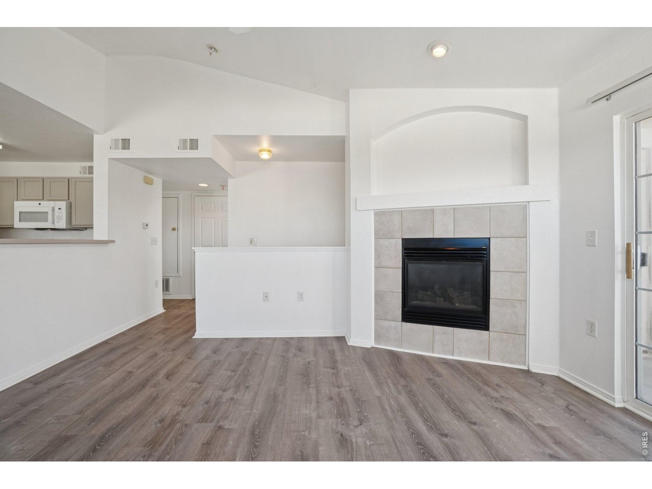3002 West Elizabeth Street, Unit 16G Fort Collins, CO 80521 - Photo 8 of 29 a view of an empty room with wooden floor and a fireplace