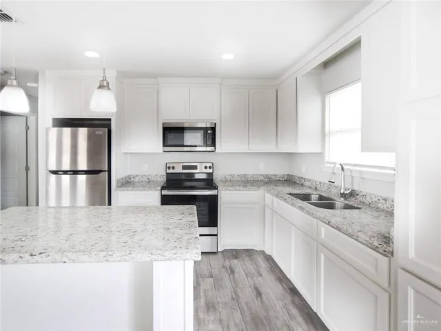 a kitchen with a sink a center island and stainless steel appliances