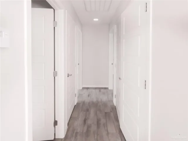 a view of a hallway with wooden floor