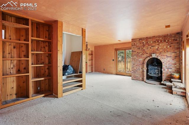 4775 Meridian Road Peyton, CO 80831 - Photo 5 of 25 Unfurnished living room featuring a wood stove and carpet