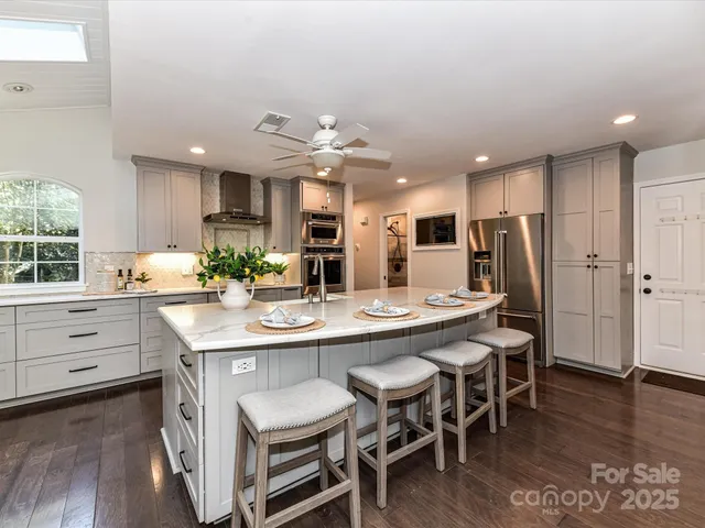 a kitchen with stainless steel appliances kitchen island granite countertop a sink and cabinets