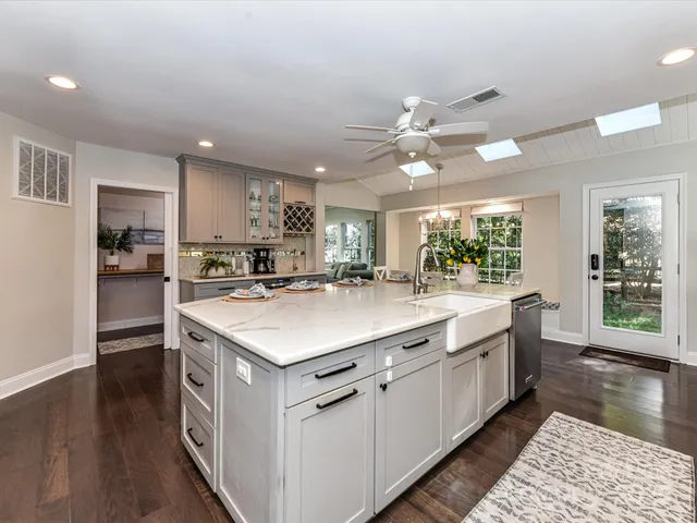 a kitchen with kitchen island a sink appliances and cabinets