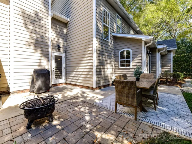 a view of a backyard with table and chairs and wooden fence