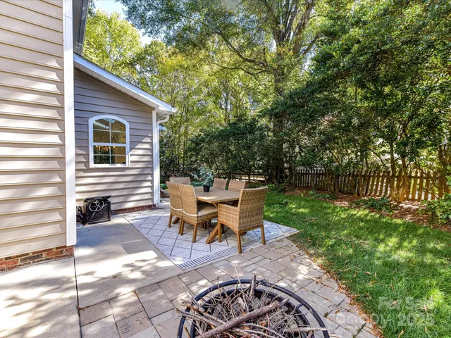 a view of a patio with table and chairs and wooden fence