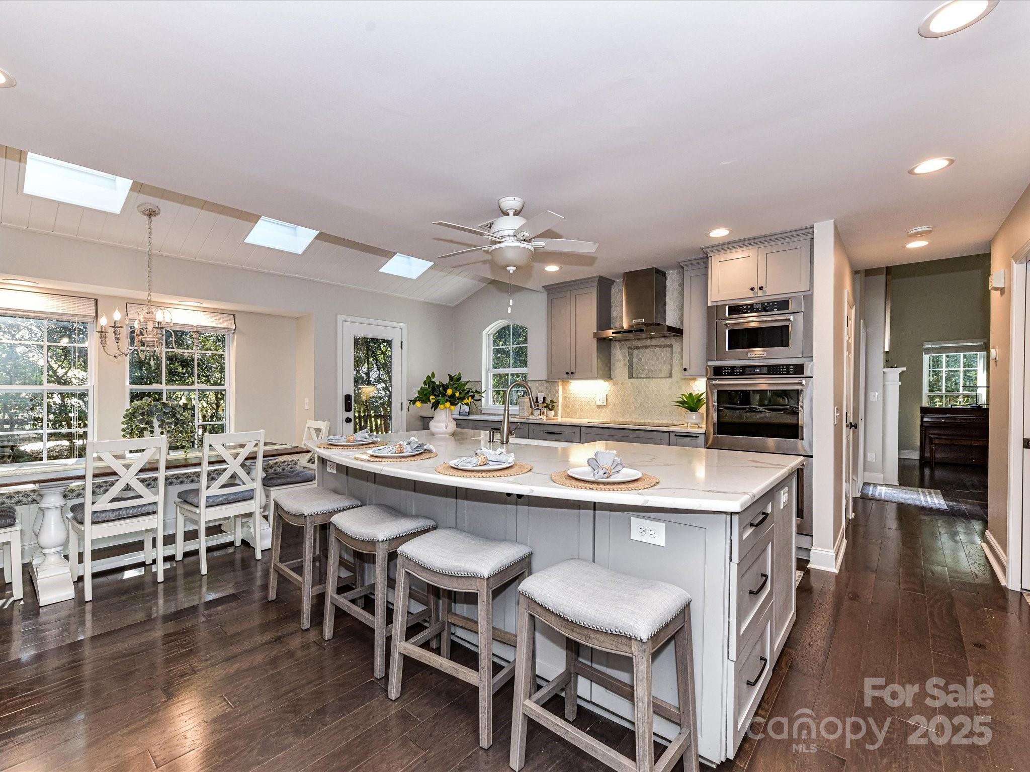 129 Shorecrest Drive Davidson, NC 28036 - Photo 9 of 45 a kitchen with kitchen island a dining table chairs and wooden floor