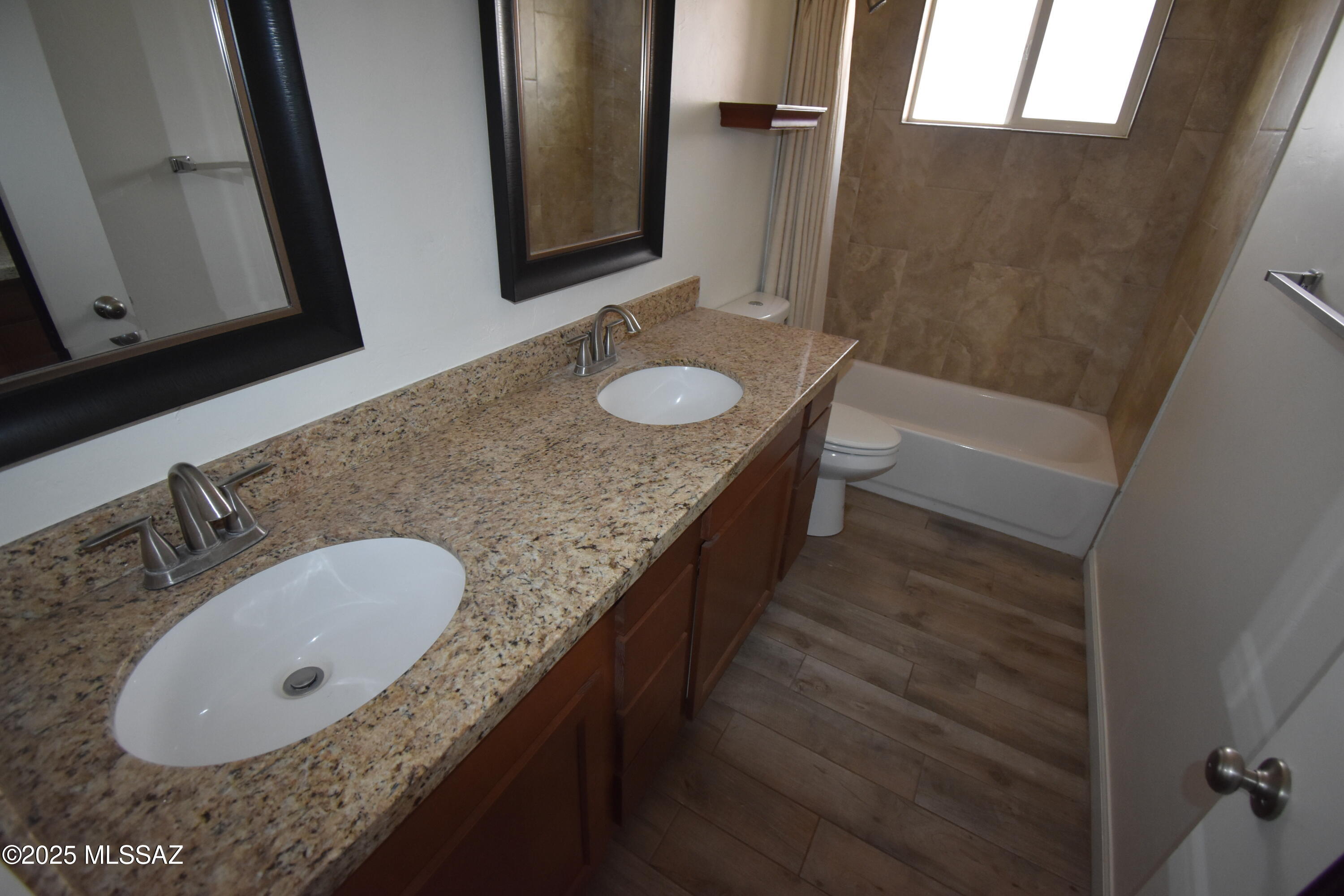 5501 East Spring Street Tucson, AZ 85712 - Photo 22 of 32 a bathroom with a granite countertop sink a mirror and bathtub