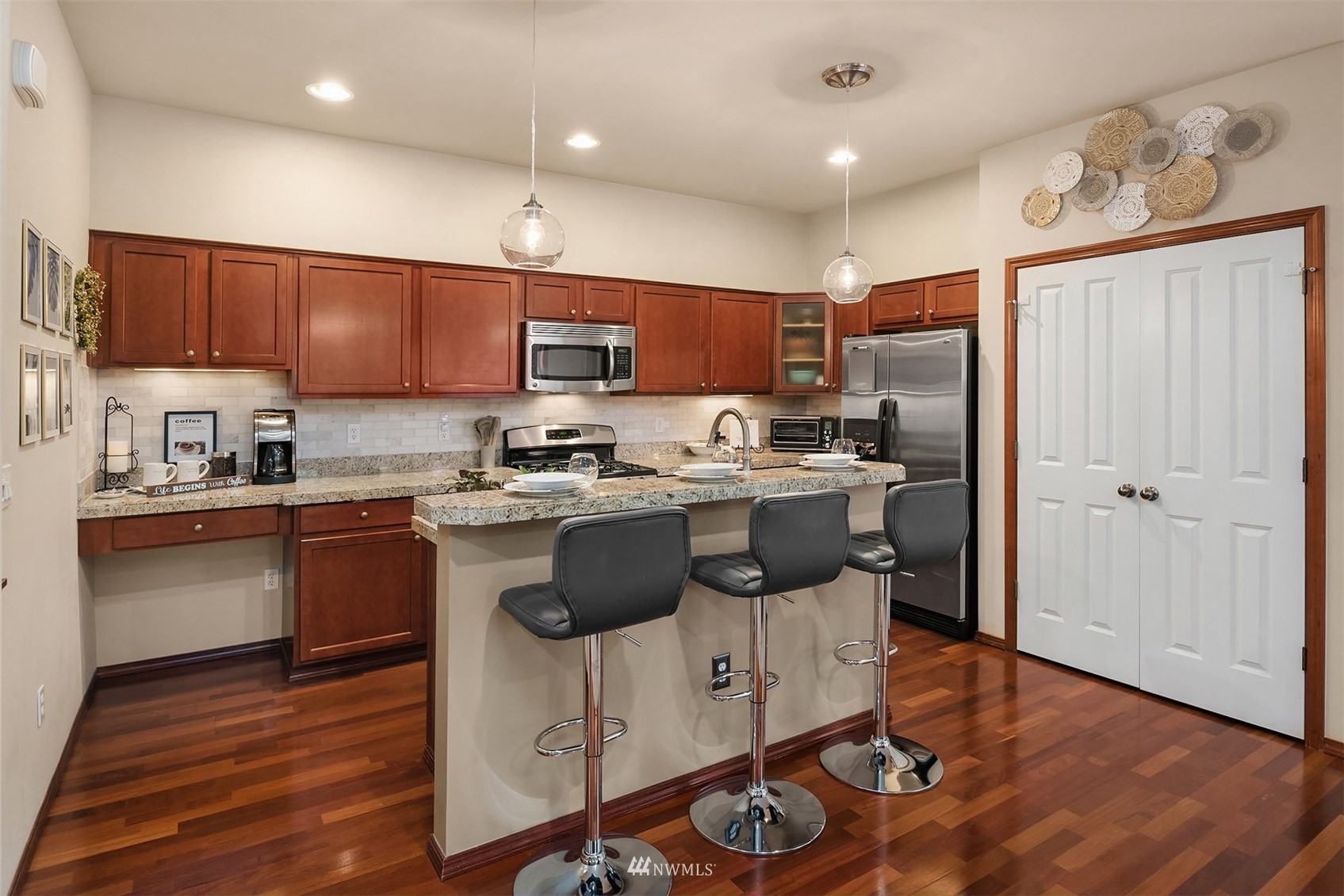 21614 11th Drive Southeast Bothell, WA 98021 - Photo 6 of 35 a kitchen with kitchen island granite countertop wooden floors stainless steel appliances a sink and a refrigerator