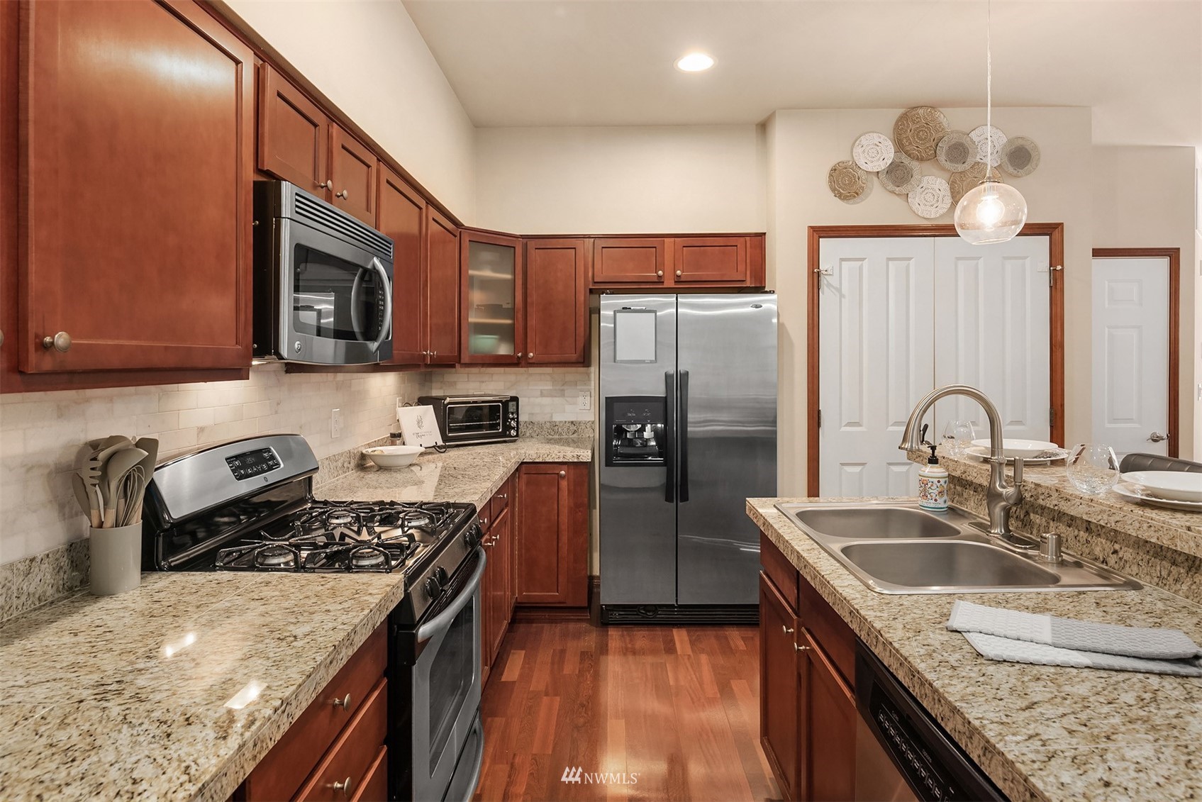 21614 11th Drive Southeast Bothell, WA 98021 - Photo 7 of 35 a kitchen with stainless steel appliances granite countertop a sink stove microwave and refrigerator