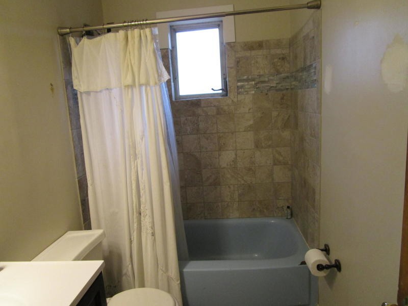 303 Walnut Valley Road Clinton, TN 37716 - Photo 15 of 19 a bathroom with a shower curtain and a toilet