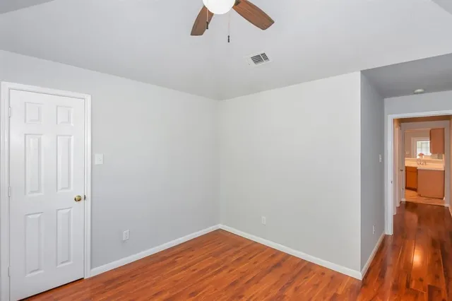 a view of empty room with wooden floor